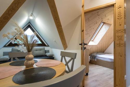 a dining room with a table and a bed in a room at Willa Jodełka in Zakopane