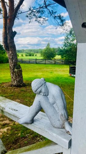 a statue of a person sitting on a bench at Na Skraju Puszczy in Cieciory