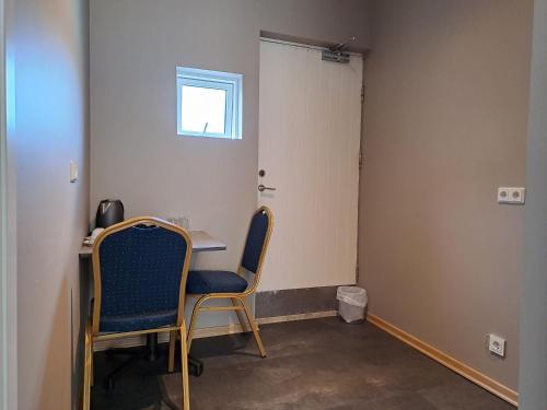 a room with two chairs and a table and a door at Hotel Studlagil in Skjöldólfsstaðir