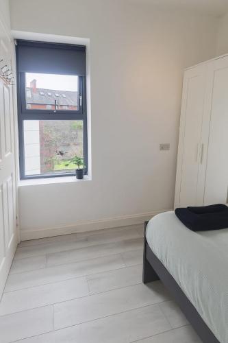 a white room with a bed and a window at Drimnagh House in Dublin