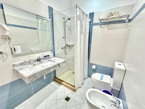 a bathroom with a sink and a toilet and a shower at Bel Ami Suita Hotel in Vlorë
