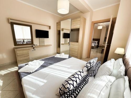 a bedroom with a large white bed with pillows at Bel Ami Suita Hotel in Vlorë