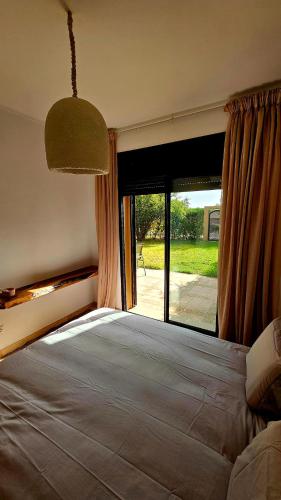 a bedroom with a large bed with a large window at Votre Villa Soleil et Chaleureuse in Marrakesh