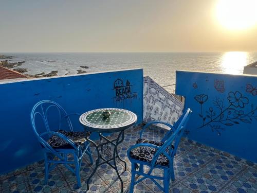 a table and two chairs sitting next to the ocean at Beach House in Asilah