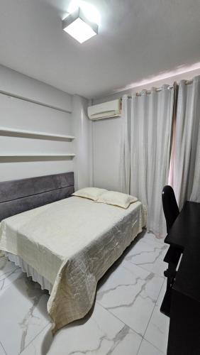 a bedroom with a bed and a desk in it at Quarto no apartamento do Edifício Ilha de Maui in Belém