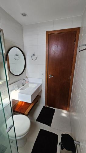 a bathroom with a sink and a toilet and a mirror at Quarto no apartamento do Edifício Ilha de Maui in Belém