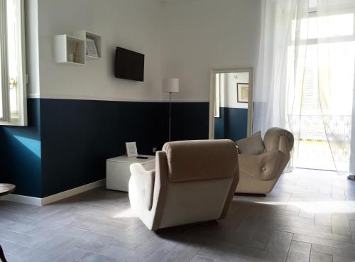 a living room with two chairs and a tv at Novecento Dimore di Poesia in Trani