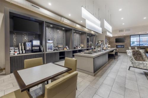 ein Restaurant mit einem Tisch, Stühlen und einer Theke in der Unterkunft Best Western Plus Executive Residency Jackson Northeast in Jackson