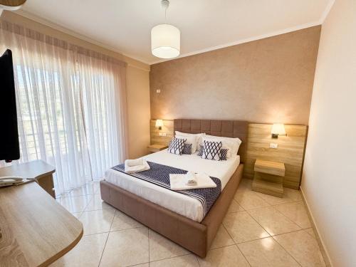 a bedroom with a bed and a large window at Bel Ami Suita Hotel in Vlorë