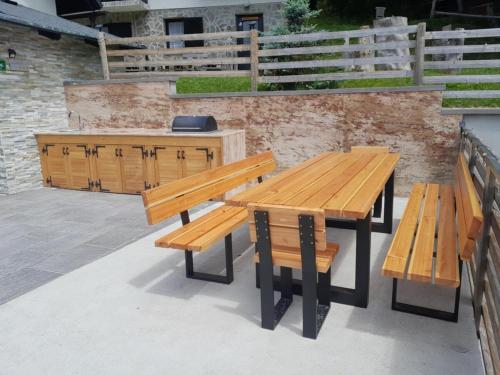 a wooden table and benches on a patio at Holiday house Nune in Zreče