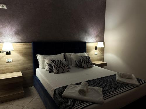 a bedroom with a large bed with towels on it at Bel Ami Suita Hotel in Vlorë