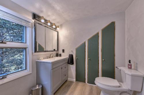 a bathroom with a toilet and a sink and a mirror at Serene and Secluded Walk Up in the Woods in Ligonier
