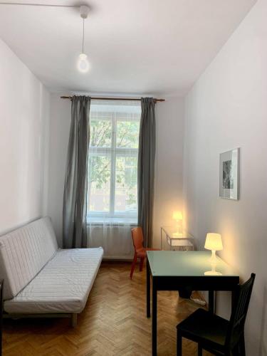 a living room with a couch and a table and a window at Enios Rooms ul Jana kochanowskiego 26 in Kraków