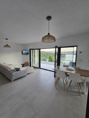 een woonkamer met een tafel en een bank bij Moon Lake Bicaz - Aurora Sky in Buhalniţa