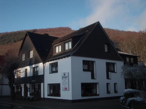 een wit gebouw met een zwart dak bij Landhotel Pingel in Sundern