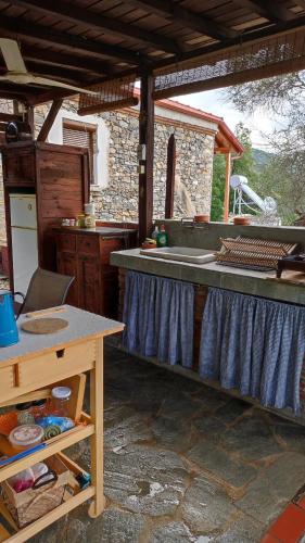 an outdoor kitchen with a counter and a sink at Μονόχωρος με αυλή in Vrasná