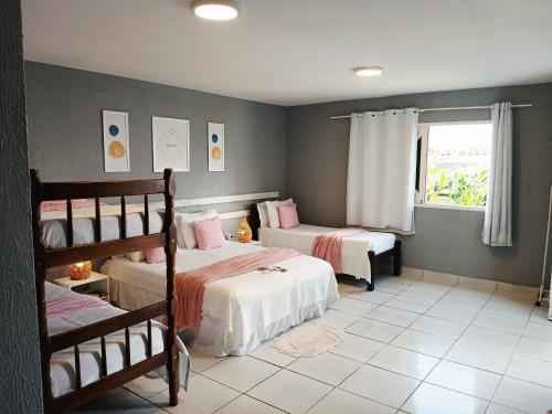 a bedroom with two bunk beds and a window at Pousada America do Sol in Natal