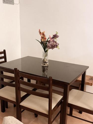 a dining room table with a vase of flowers on it at The Nook 12 in Malolos