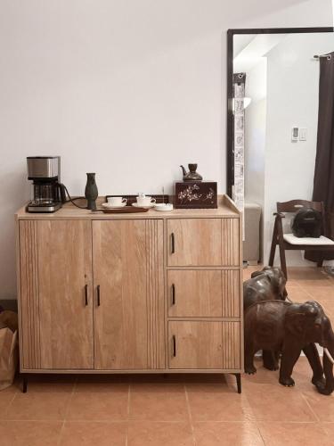 a dog is standing next to a wooden cabinet at The Nook 12 in Malolos
