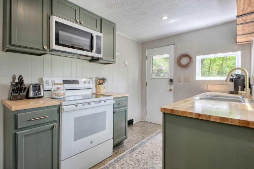 a kitchen with green cabinets and a white stove top oven at Relax and Unwind - Bird Creek Cottage at Cliffwood in Ligonier