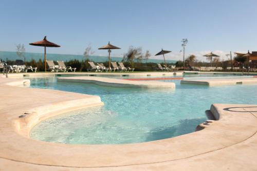 a large swimming pool with chairs and umbrellas at Casa Sueno Dream in Playa Honda