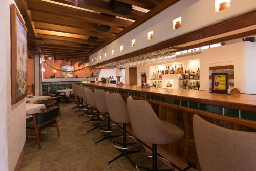 a bar with a row of chairs in a restaurant at Hotel Bougainvillea San José in Santo Domingo