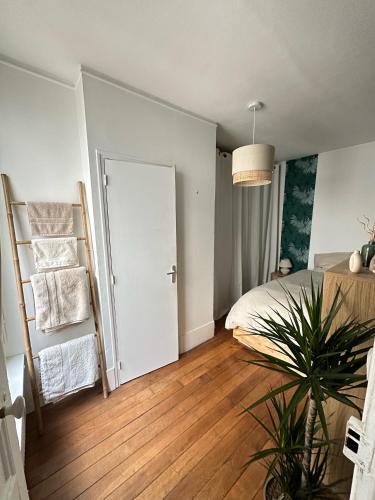 une chambre avec un lit et une plante en pot dans l'établissement Appartement proche Montmartre, à Paris