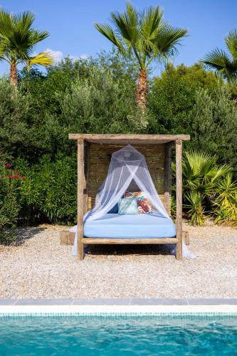 a bed in a canopy next to a swimming pool at Fidalsa Divine Hiding in Algorfa
