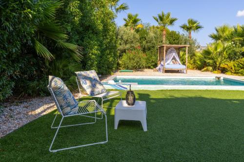 two chairs and a table next to a swimming pool at Fidalsa Divine Hiding in Algorfa