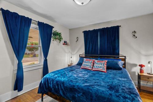 a bedroom with blue curtains and a bed with two pillows at Coca Cola Cottage - Stay & Play Near Purina Farms - Dog Friendly in Pacific