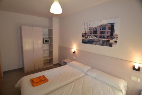 a bedroom with a bed and a painting on the wall at Apartamentos Marina Suites in Grao de Castellón