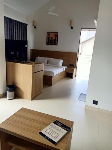 a bedroom with a bed and a table with a book at Mountain Shadow Resort in Igatpuri