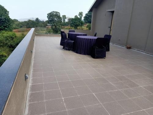 a room with tables and chairs on a roof at Mountain Shadow Resort in Igatpuri