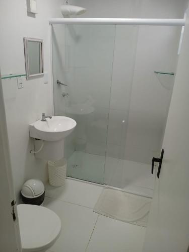 a white bathroom with a shower and a sink at Pousada America do Sol in Natal