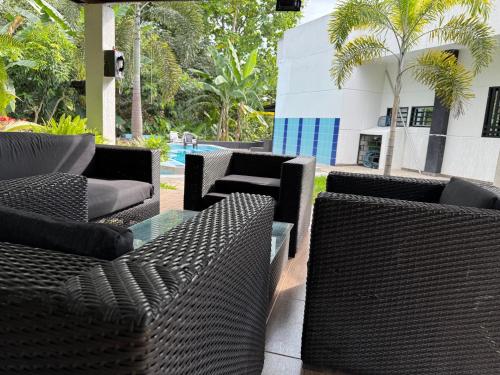 a group of wicker chairs and tables on a patio at Finca Casa Mercedes rivera in Rivera