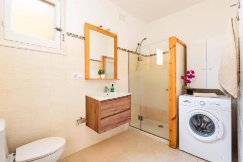 a bathroom with a washing machine and a washer at Villa Las Mariposas by Villa Plus in Es Mercadal