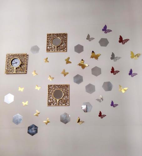 a wall with butterflies and a clock on it at Casa Entre Rocas y Veleros in Los Órganos