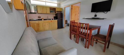 a living room with a couch and a table and a kitchen at Ballena Rey Hotel in Uvita