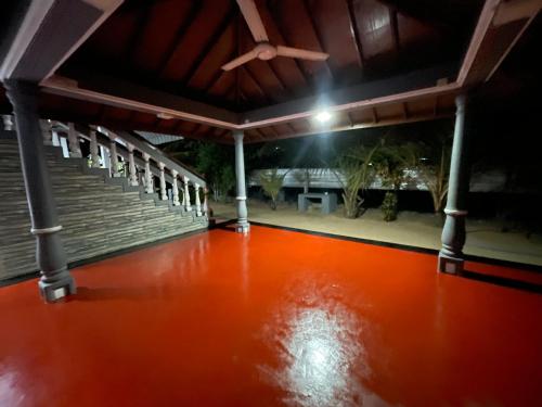 an empty room with an orange floor and a porch at Dutch guest house in Kallady