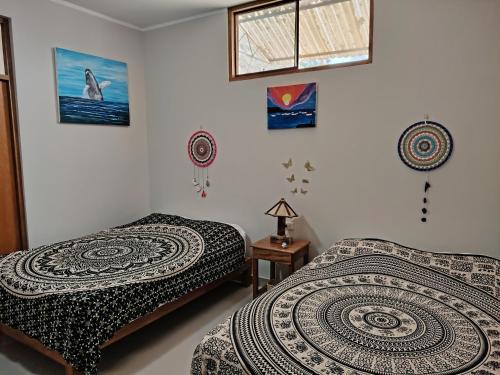 a bedroom with two beds and a window at Casa Entre Rocas y Veleros in Los Órganos