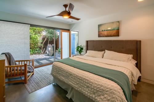 a bedroom with a large bed and a sliding glass door at Seascape by Paradise Retreats in Carpinteria
