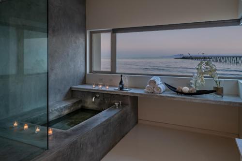 a bathroom with a bath tub with a view of the ocean at Seascape by Paradise Retreats in Carpinteria