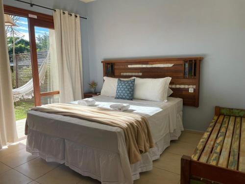 a bedroom with a large bed and a window at Pousada Rosamar in Praia do Rosa