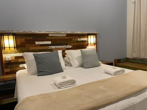a bedroom with a large bed with two towels on it at Pousada Rosamar in Praia do Rosa