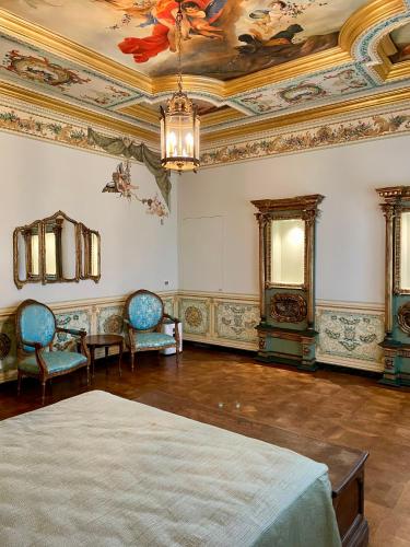 a room with a bed and chairs and a ceiling at Residenza Rinascimento 