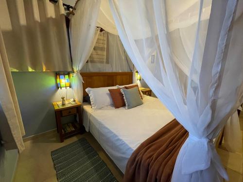 a bedroom with a bed with a canopy at Pousada Rosamar in Praia do Rosa
