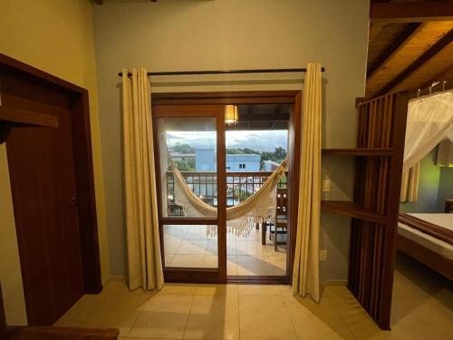 a room with a door open to a balcony at Pousada Rosamar in Praia do Rosa
