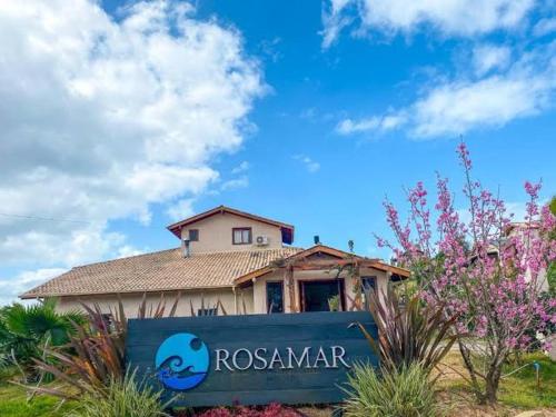 a house with a sign in front of it at Pousada Rosamar in Praia do Rosa