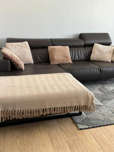 a black leather couch sitting in a living room at Urban Comfort Mechelen in Mechelen
