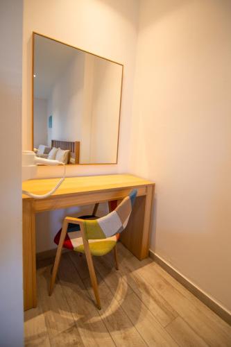 a desk with a mirror and a chair in a room at Riviera Perdika Hotel in Perdika